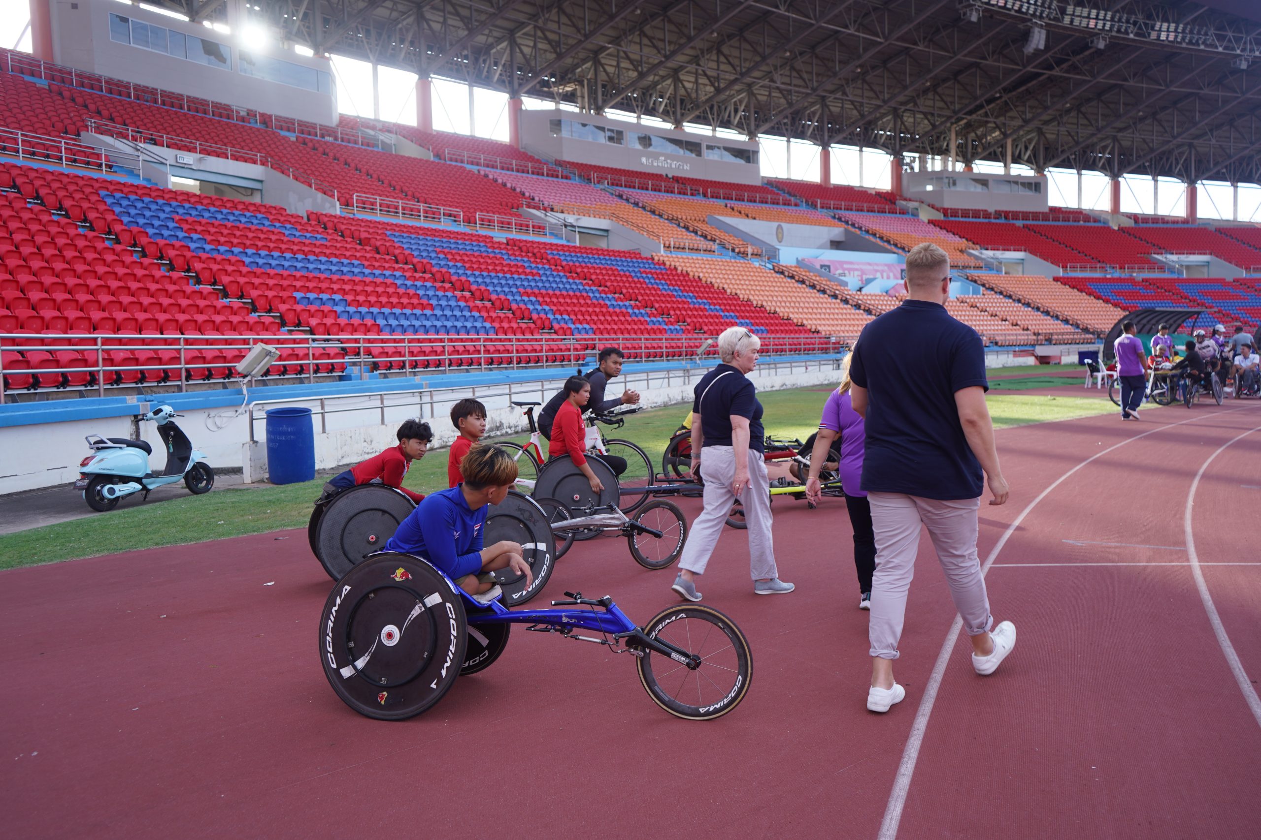 Officials from World Abilitysport are pictured on the athletics track at the stadium. They are joined by a number of athletes in racing wheelchairs.